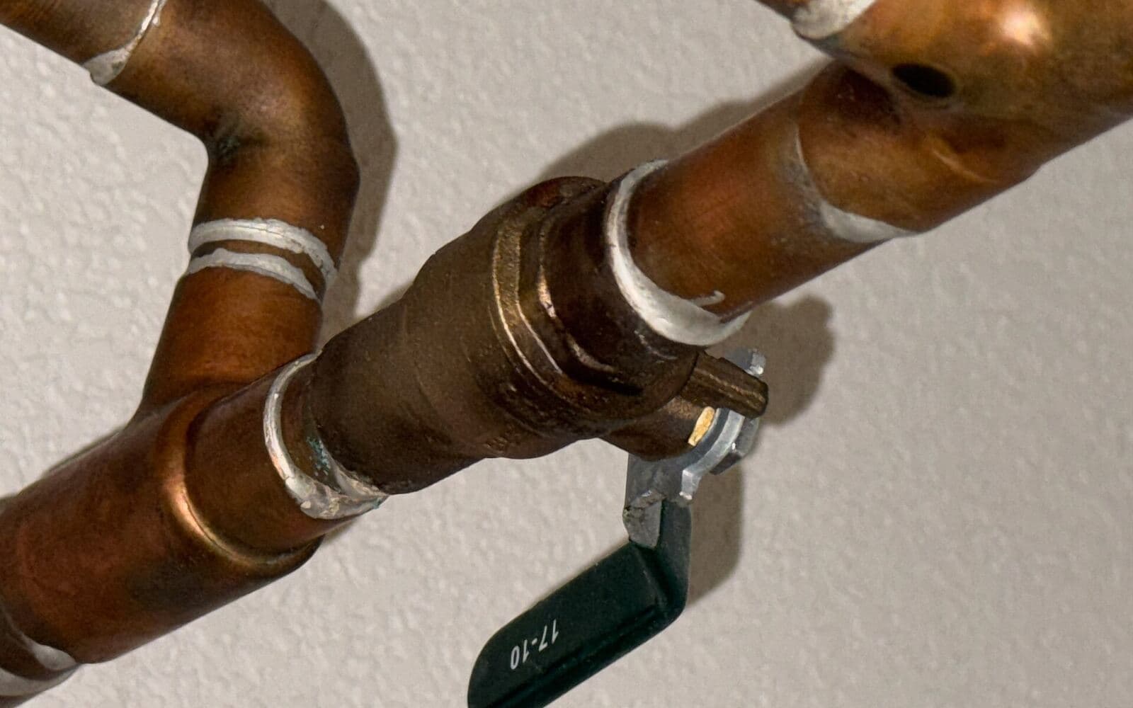 Copper water supply lines and a ball-valve shutoff in a home’s plumbing
