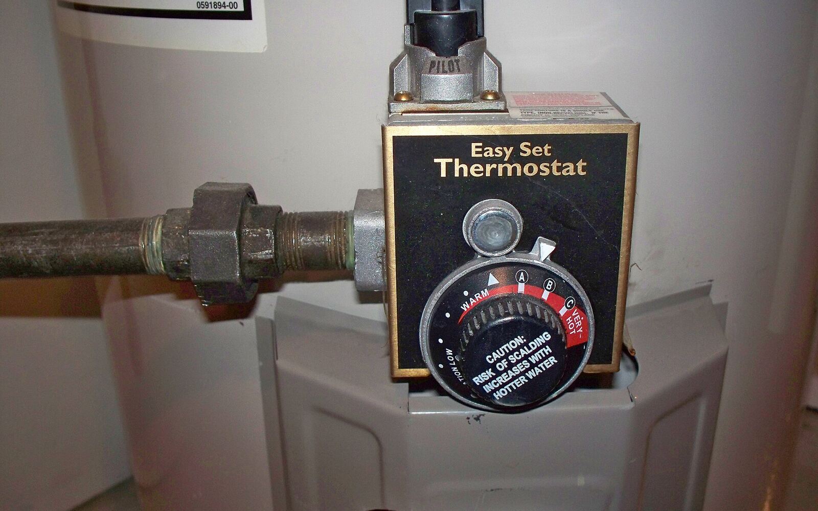 The gas control valve and temperature dial on a residential tank water heater